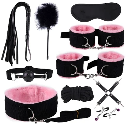 Set BDSM negru cu blăniță roz: două perechi de cătușe, zgardă cu lesă, căluș cu bilă, bici cu franjuri, pană, mască, frânghie, conector în X și cleme cu clopoței
